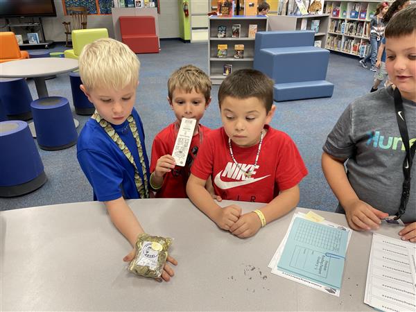 1st graders looking at the coins